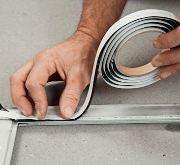 Fäst nu det dubbelhäftande butylbandet på glasningslisterna Fäst nu det dubbelhäftande butylbandet på glasningslisterna